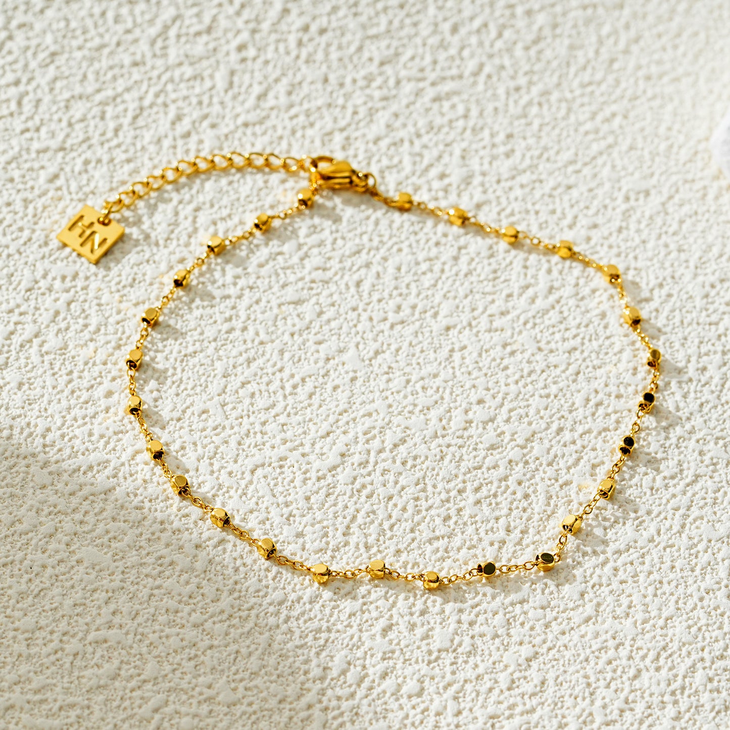 Style DEMELZA 8191G: Contemporary Gold Anklet with Delicate Square Beads. 