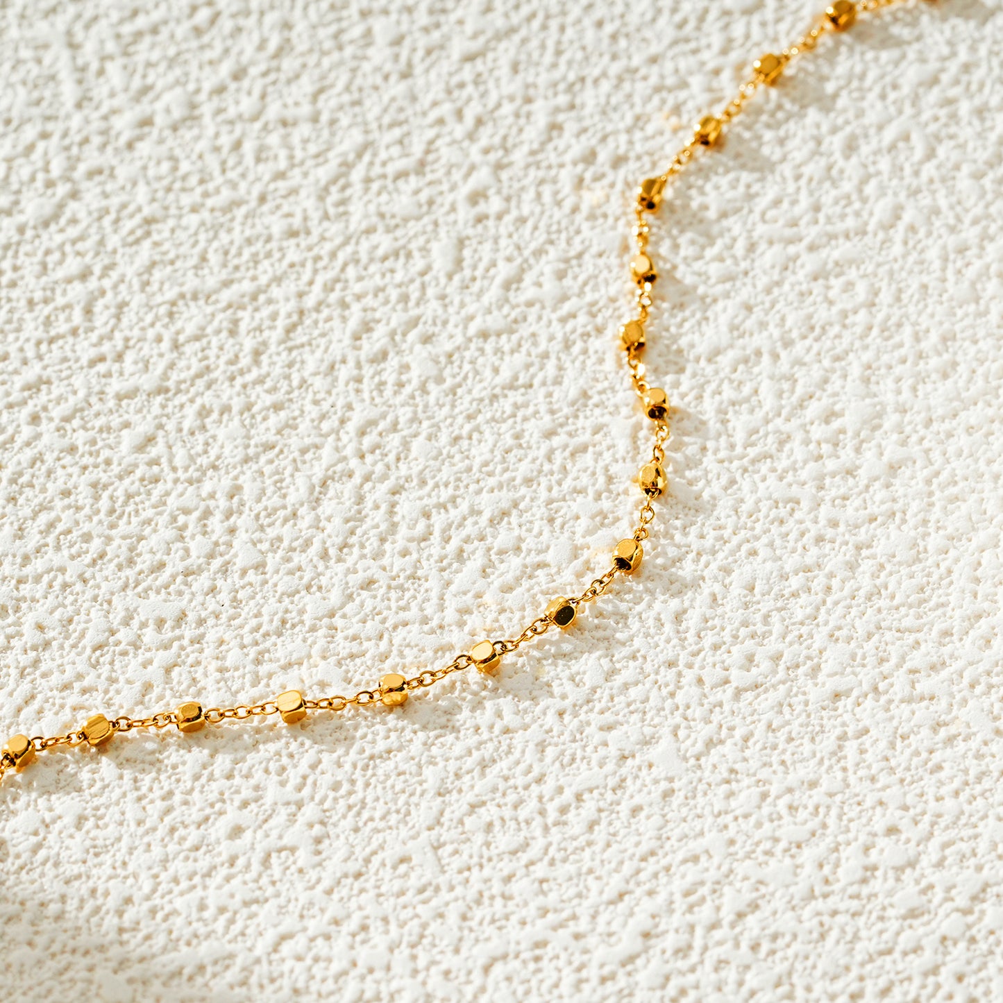 Style DEMELZA 8191G: Contemporary Gold Anklet with Delicate Square Beads. 