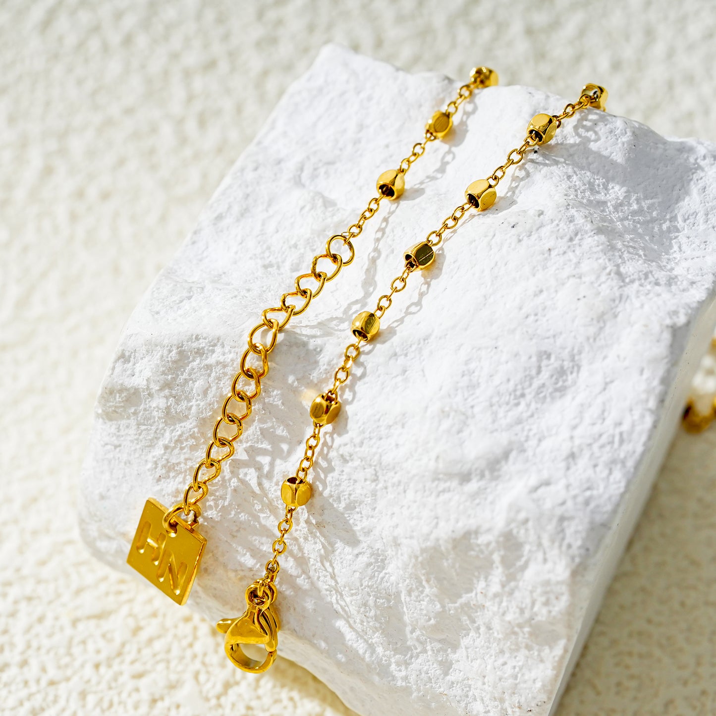 Style DEMELZA 8191G: Contemporary Gold Anklet with Delicate Square Beads. 