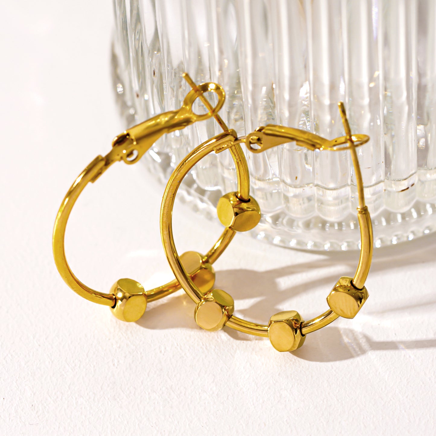 Style MASUYO 1079: Avant-Garde Rounded Hoop Earrings Anchoring a Trio of Square Beads.