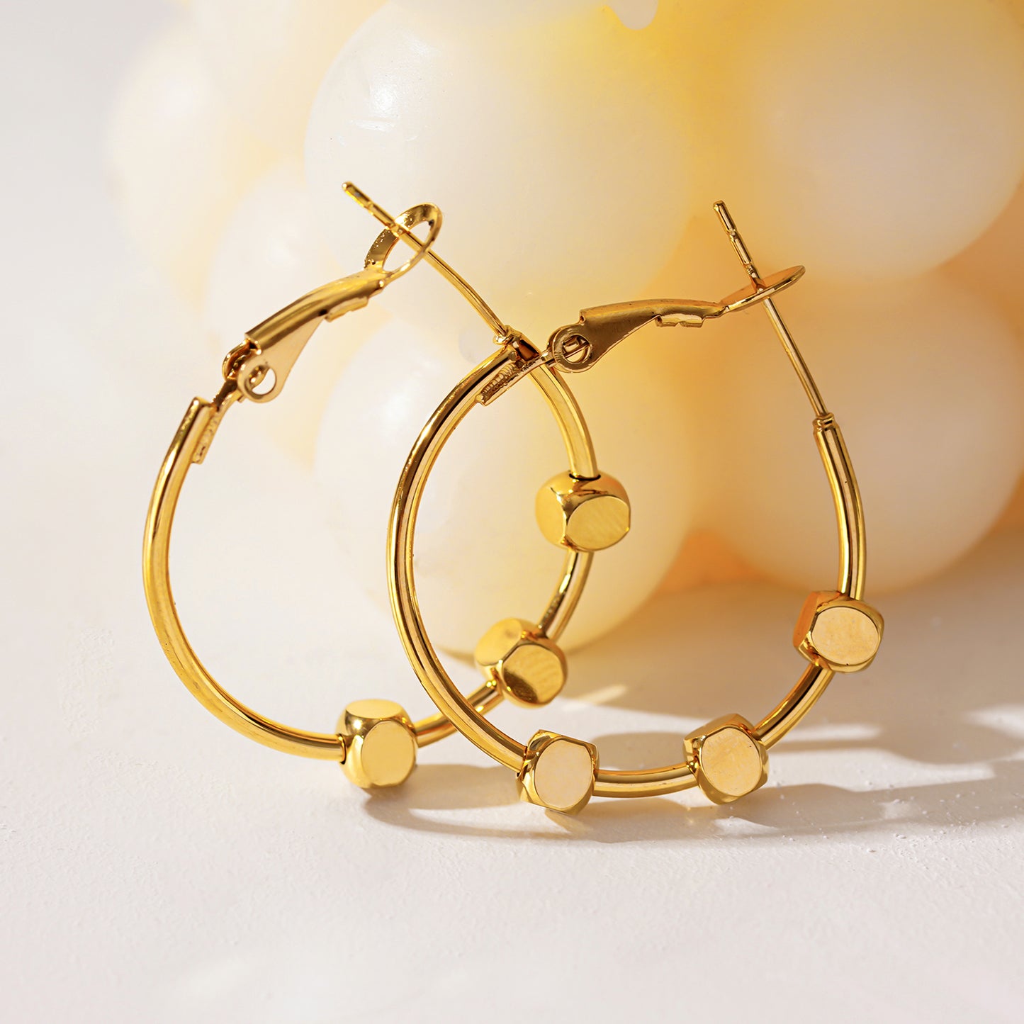 Style MASUYO 1079: Avant-Garde Rounded Hoop Earrings Anchoring a Trio of Square Beads.