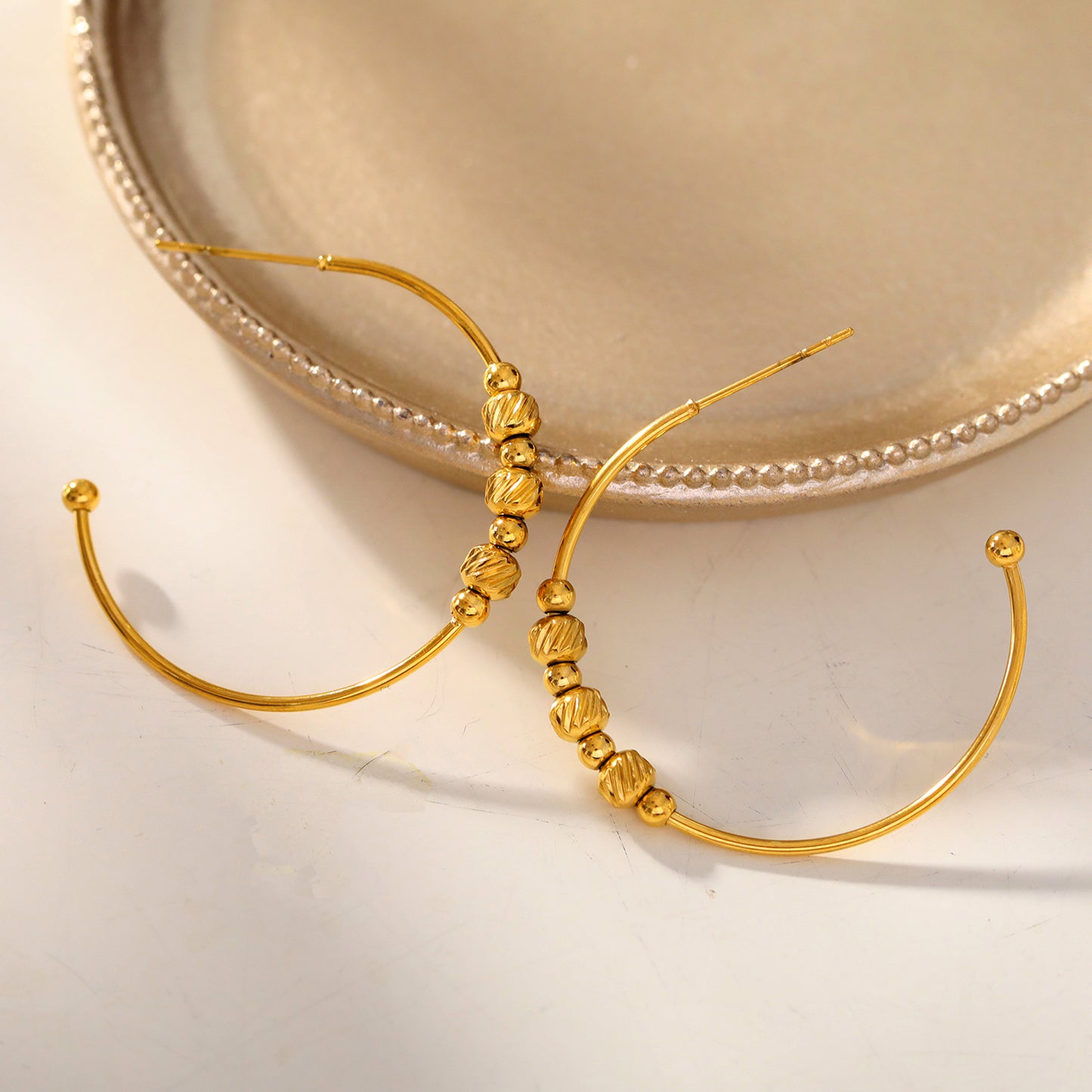 CHARIS: Classic Round Hoop Earrings Anchoring a Bevy of Charm Beads