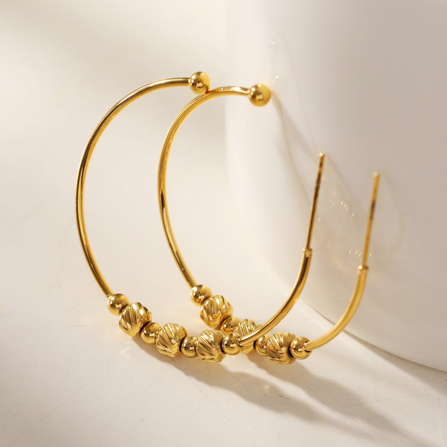 CHARIS: Classic Round Hoop Earrings Anchoring a Bevy of Charm Beads