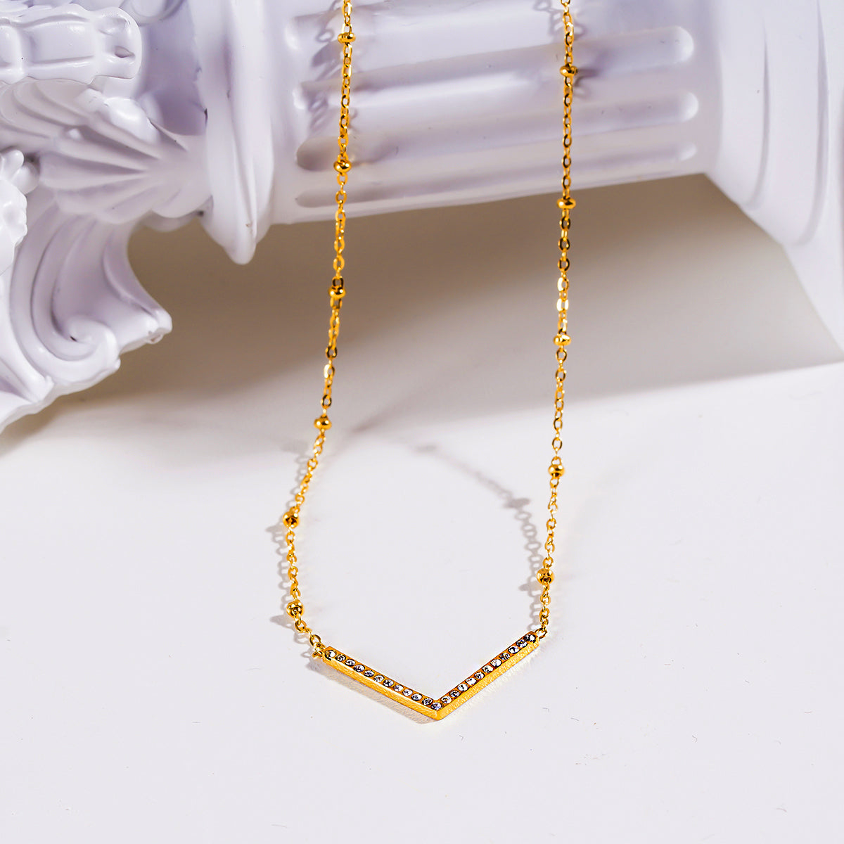 Style SANITA 9712: Beaded Dainty Chain Anchoring 'V' Shaped Zirconia Embedded Pendant Charm.